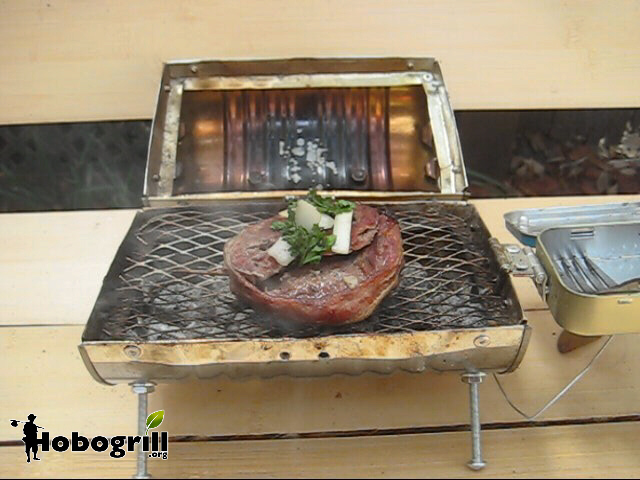 hobo campstove cooking on a park bench, bacon wrapped filet mignon, topped with onion